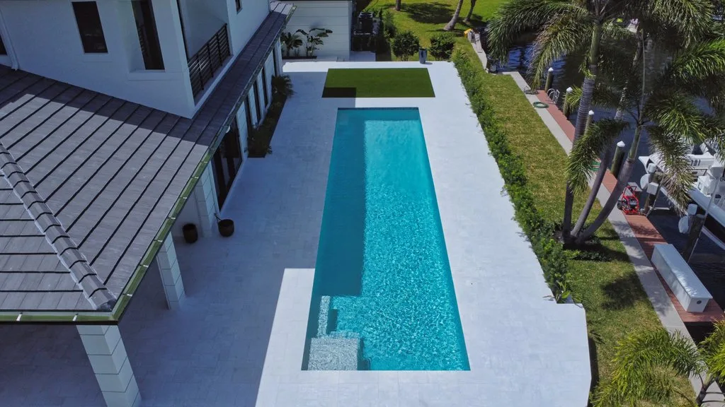 Aerial of long linear pool beside the home, custom pool builder in North Palm Beach, FL