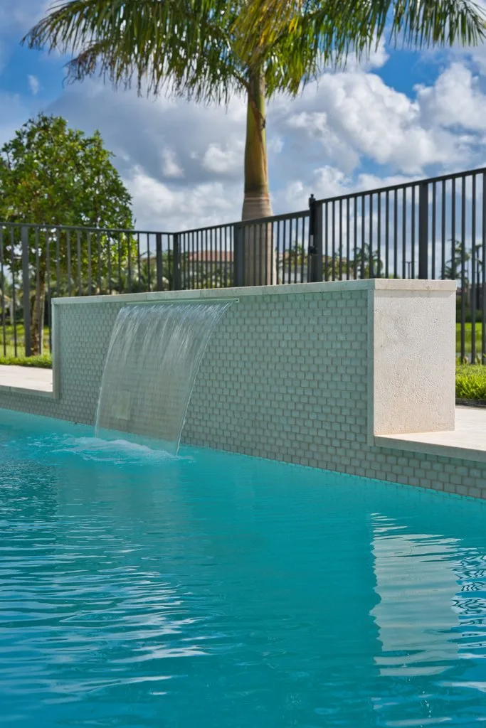Tiled water wall spilling into a custom pool in west Boynton Beach