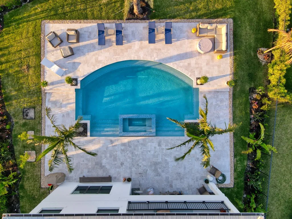 Aerial view of a custom pool and spa with travertine deck in Palm Beach Gardens, FL