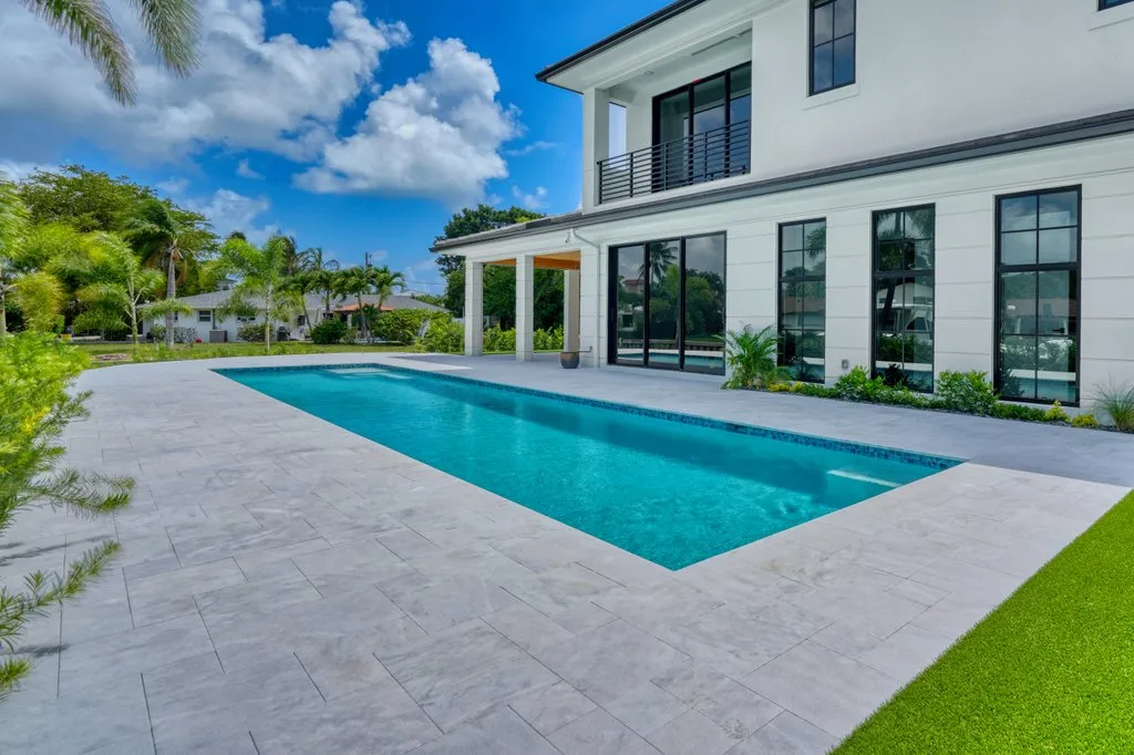 Marble paver deck wrapping the pool, custom pool builder in North Palm Beach, FL
